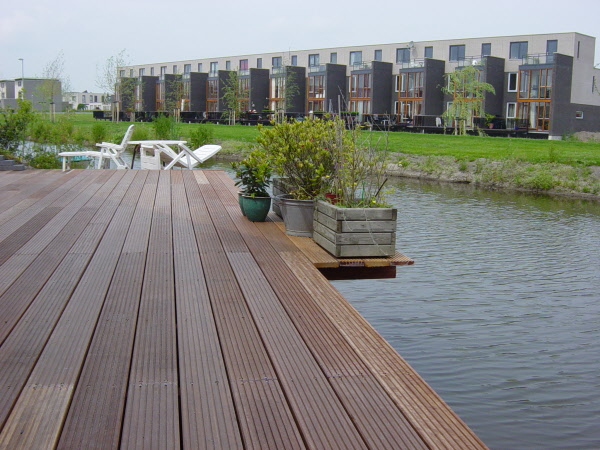 Tuin met borderbakken en groot hardhouten vlonder met trap aan het water DECAtuinen hovenier Almere Flevoland
