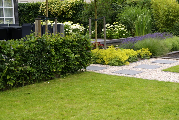 Grote, strakke, kindvriendelijke tuin met vijver, zitkuil en groot terras DECAtuinen hoveniers Almere Flevoland