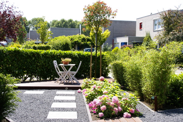 Strakke tuin aan het water met zonneterras en tuindouche Hoveniersbedrijf DECAtuinen Almere Flevoland