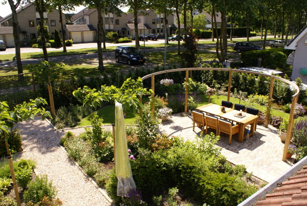 Gezellige tuin met speelplek voor kinderen en ronde pergola DECAtuinen hoveniers Almere Flevoland