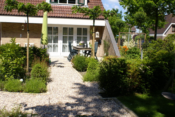 Gezellige tuin met speelplek voor kinderen en ronde pergola DECAtuinen hoveniers Almere Flevoland