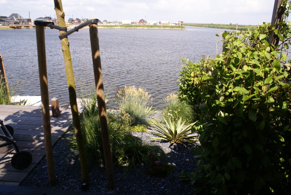 Moderne tuin aan het water met schanskorven DECAtuinen hoveniers Almere Flevoland