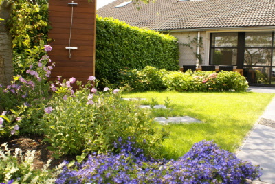 Strakke tuin aan het water met zonneterras en tuindouche Hoveniersbedrijf DECAtuinen Almere Flevoland