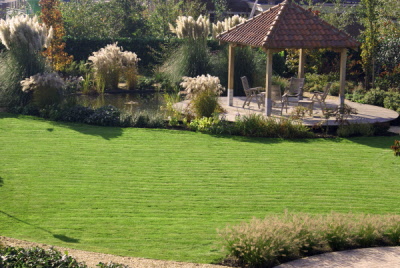 Landelijke tuin met ronde vijver en zwembad Hoveniersbedrijf DECAtuinen Almere Flevoland